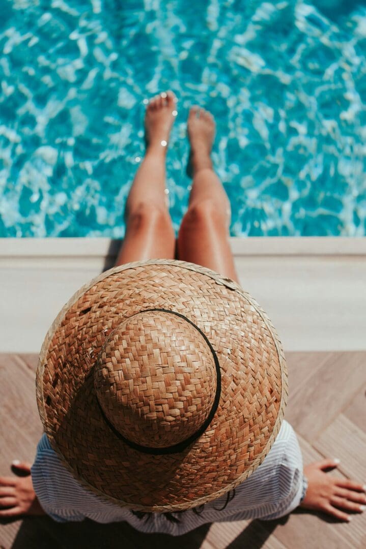 A person with a hat sitting in the pool