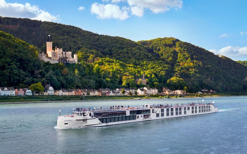 Cruise ship sailing past a castle.