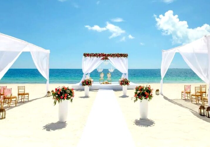 Beach wedding ceremony with white drapes.